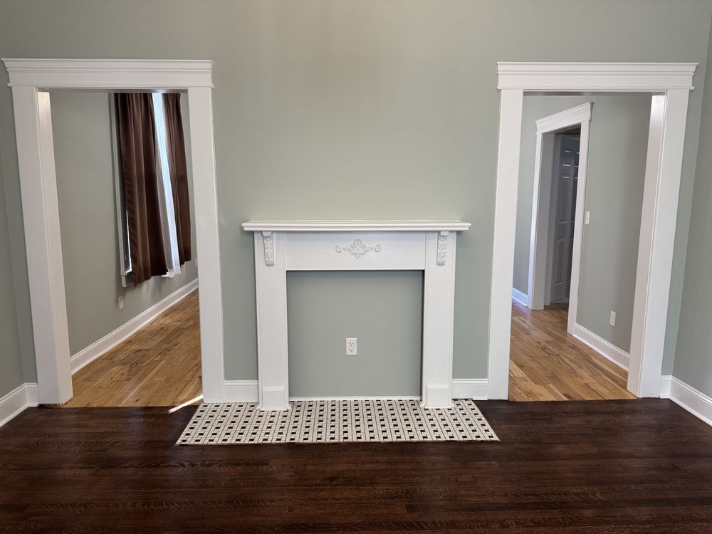 Room with sage-green walls and a white mantel