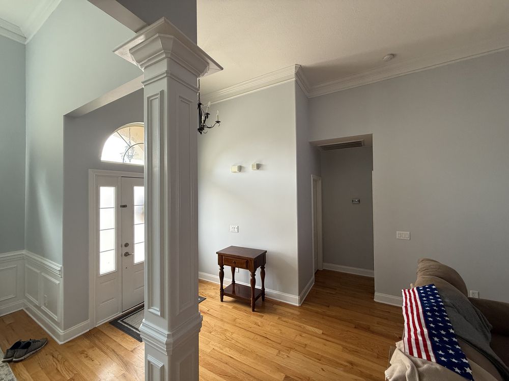 Entry foyer with a white column and arched doorway