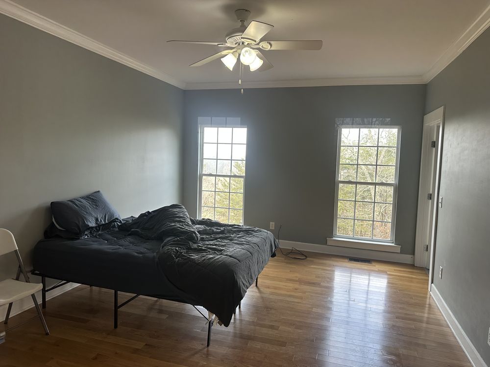 Bedroom with soft sage walls and hardwood floors