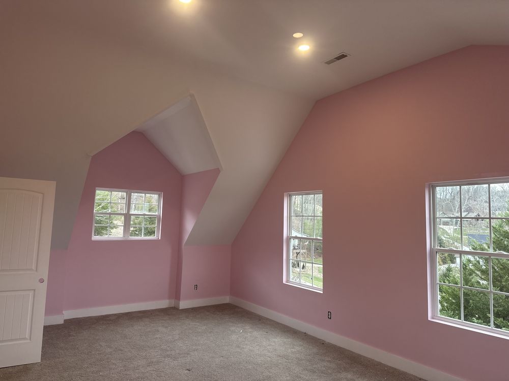 Bedroom with soft pink walls and a vaulted ceiling