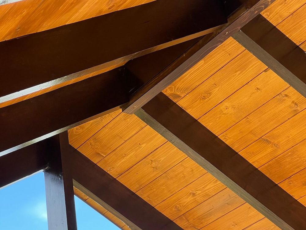 Richly stained wood pergola — two-tone deck and beam staining