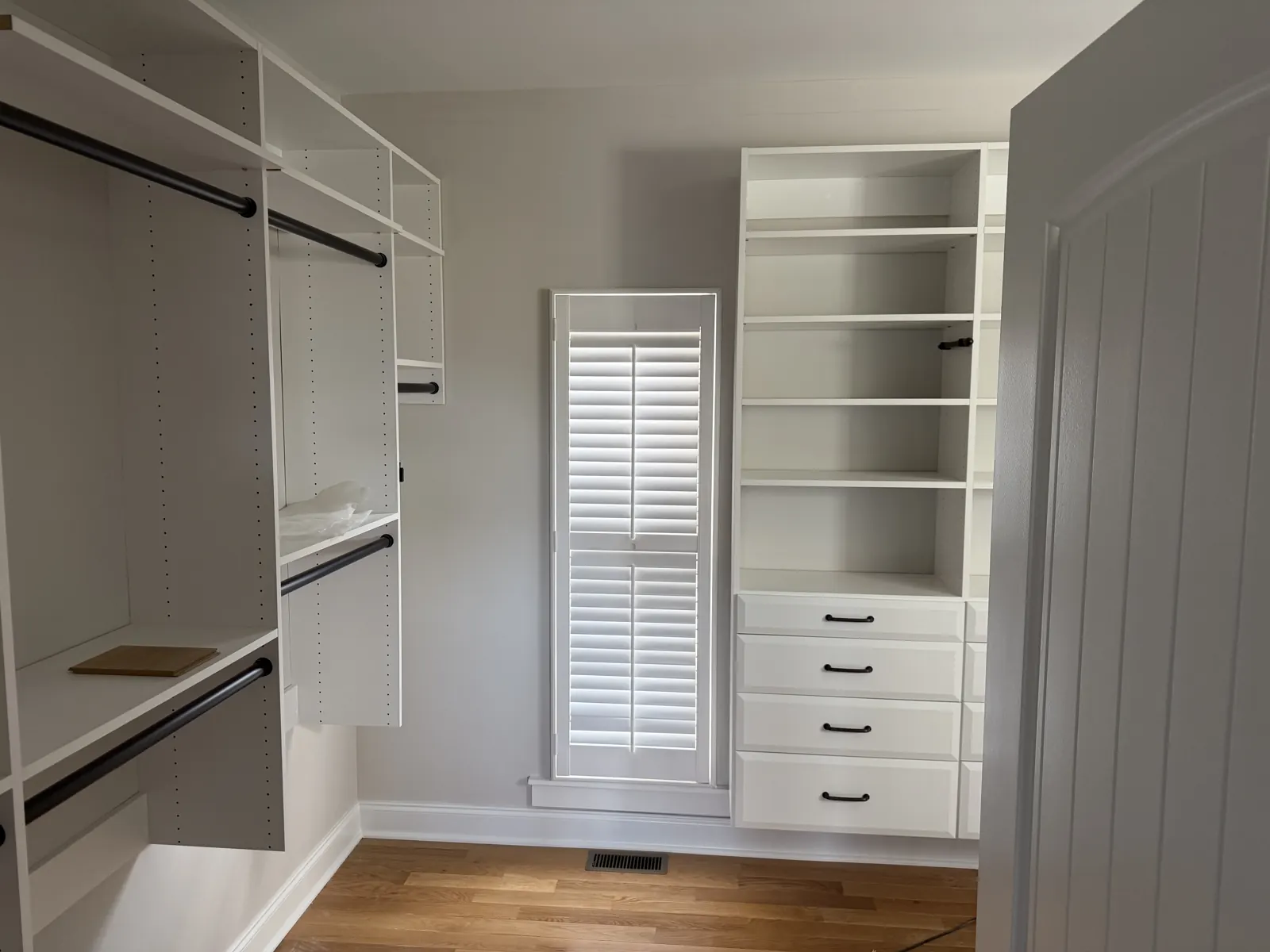 Walk-in closet built-ins with drawers and shelving painted white in Harrison, TN