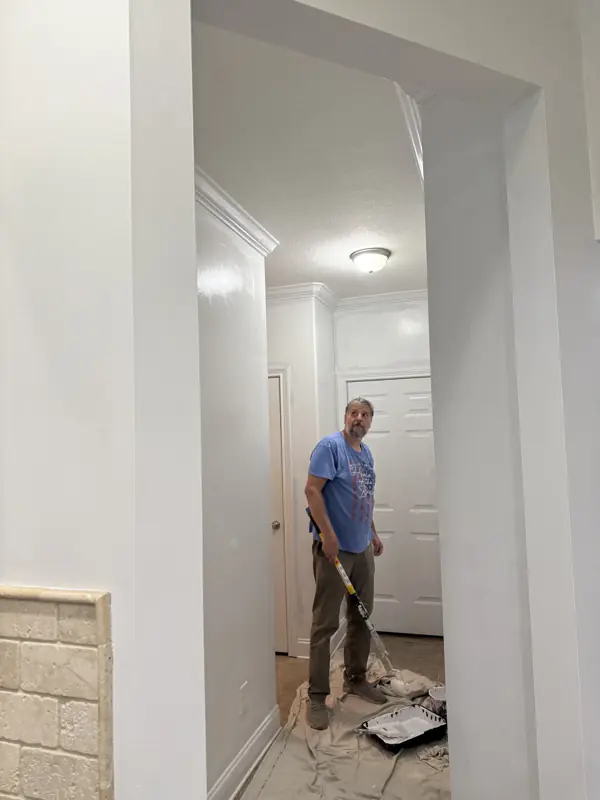Painter cutting in a hallway with drop cloths down in Ooltewah, TN