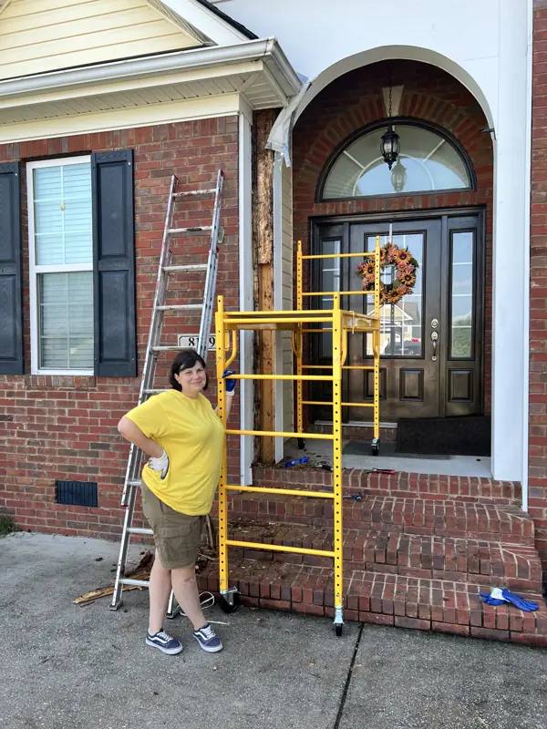 Crew member setting up scaffold and ladder at a brick front entry in Ooltewah, TN