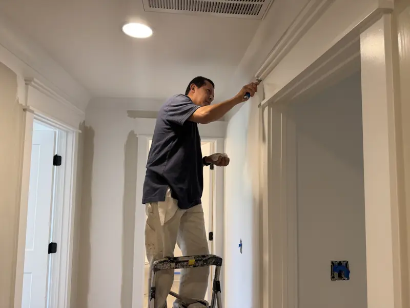 Painter on a step ladder cutting in trim around a doorway in Soddy-Daisy, TN