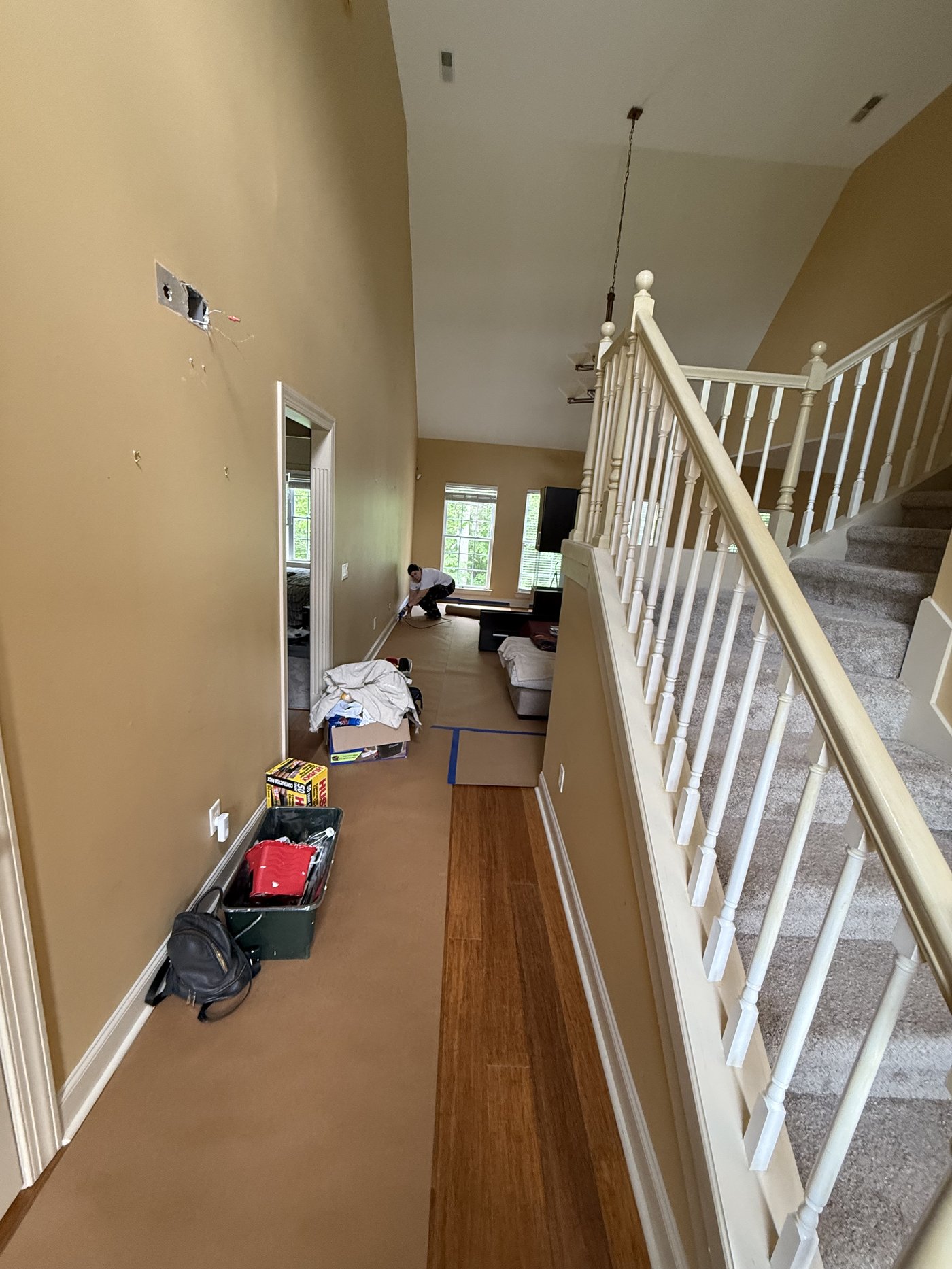 Two-story foyer prep showing protection setup from side angle